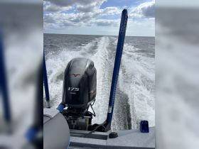 A powerful Yamaha motor propels a boat through open waters, leaving a wake behind — perfect for fishing or leisure cruising.