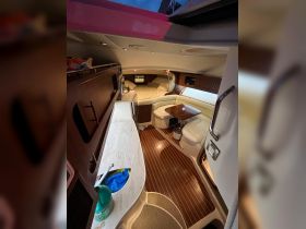 Interior view of a cozy boat cabin featuring a seating area and sleeping quarters, perfect for relaxing during overnight trips.