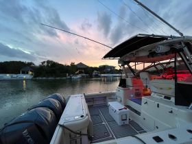 A serene view of the interior of a boat, showcasing the helm and seating area, perfect for relaxing before setting out on an evening cruise.