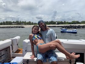 A joyful moment captured on a boat, featuring a man and a girl enjoying their time together, perfect for family outings and memorable experiences on the water.