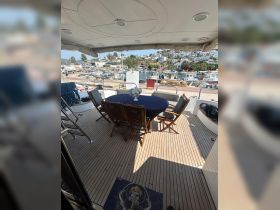 A beautifully arranged dining area on a boat, featuring a table set for guests and a view of the marina, perfect for enjoying meals while at sea.