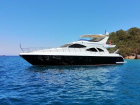 A sleek yacht glides through clear blue waters, showcasing its elegant design and perfect for luxury charters or day trips.
