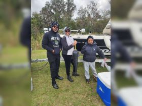 A family proudly displays their catch after a successful fishing trip, showcasing a memorable outdoor experience together.