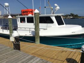 A side view of a docked boat showcasing its sleek design and vibrant colors, perfect for fishing or leisure activities on the water.