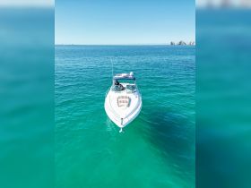 A stunning aerial view of a sleek speedboat cruising through crystal-clear turquoise waters, perfect for a day of adventure on the sea.