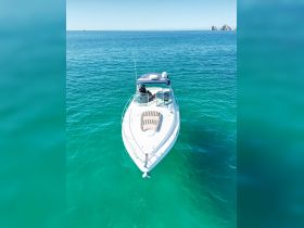 Aerial view of a sleek speedboat cruising through crystal-clear turquoise waters, showcasing the perfect vessel for a day of adventure on the ocean.