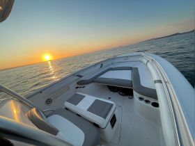 A serene view of the interior seating area of a boat, capturing the beautiful sunset over the water — perfect for relaxing moments on the water.
