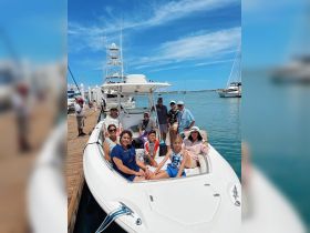 A cheerful family gathers on a boat at the marina, ready for a day of adventure on the water. Perfect for family outings and group excursions.
