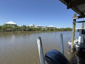 A view of a waterway with houses in the background, but the focus is unclear and lacks identifiable features.