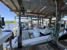 Inside view of a well-equipped boat cabin featuring a helm and seating area, perfect for fishing or leisure outings.