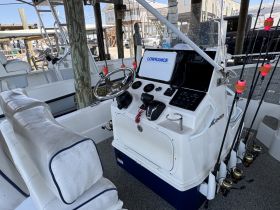 The interior helm of a fishing boat showcases a well-equipped console and comfortable seating, ideal for a day out on the water.