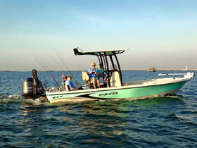 A lively group enjoys a fishing trip aboard a Blue Wave boat, showcasing the fun and camaraderie of a day on the water.