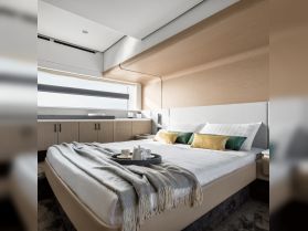 A beautifully designed boat cabin featuring a cozy bedroom setup with elegant decor, perfect for relaxing on the water.