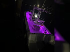 A well-lit interior view of a boat's helm area, showcasing modern equipment and ambient lighting, perfect for nighttime fishing or cruising.