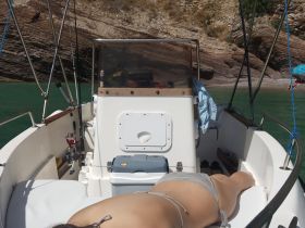 A relaxing moment aboard a boat, showcasing the interior seating area with a person lounging comfortably. Perfect for enjoying a day on the water.