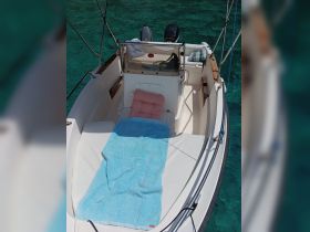 A serene view of the interior seating area of a boat, featuring a cozy setup with towels and cushions, perfect for relaxation on the water.