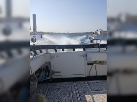 View from the helm of a boat, showcasing the console and the wake created as it moves through the water — perfect for fishing or leisure trips.