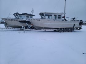Two boats, 'Tolstoi Point' and 'Black Point', are docked in a snowy environment, showcasing their structure and design during winter.
