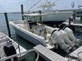 A sleek speedboat docked at the marina, showcasing its powerful twin engines and spacious design, perfect for thrilling water adventures.