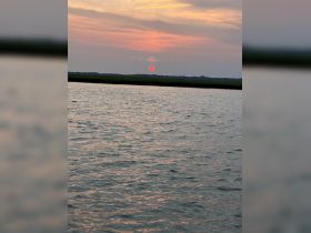 A stunning sunset reflects on the water, creating a picturesque scene perfect for evening boat trips and relaxation on the water.
