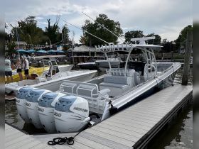 A sleek speedboat docked at a marina, showcasing its powerful Mercury engines and spacious seating, perfect for thrilling water adventures.