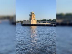 A view of a lighthouse on the waterfront, surrounded by water. The image lacks clarity and detail.