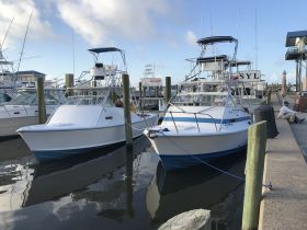 Two fishing boats docked at the marina, showcasing their sleek designs and readiness for a day on the water.