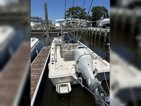 A detailed view of a center console boat docked at the marina, showcasing its sleek design and fishing gear, perfect for a day on the water.