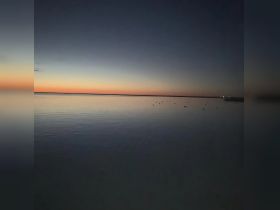 A serene sunset over calm waters, creating a picturesque reflection — perfect for tranquil boating experiences.