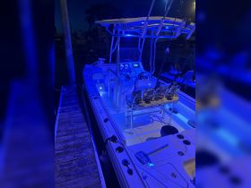 A well-lit interior view of a boat's helm and seating area, showcasing modern features and amenities, perfect for nighttime excursions.