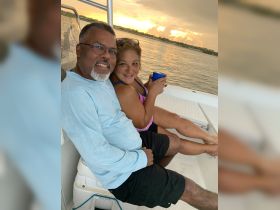 A couple enjoys drinks together on a boat at sunset, capturing a perfect moment of relaxation and celebration on the water.