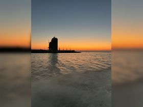 A stunning sunset view over the harbor, with silhouettes of structures reflecting on the water — perfect for capturing the beauty of evening boat trips.