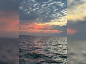 A stunning sunset over calm waters, showcasing the beauty of nature — perfect for serene evening boat rides.