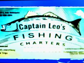 An unclear image of a fishing charter advertisement featuring Captain Leo's Fishing Charters, with contact information partially visible.