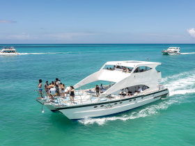 A lively group enjoys a day on a yacht, celebrating and soaking up the sun in beautiful turquoise waters — perfect for unforgettable summer outings.
