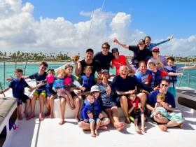 A joyful family group poses on a boat, showcasing smiles and excitement during their fun-filled day on the water — perfect for memorable family outings.