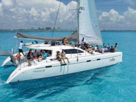 A lively group enjoys a day on a catamaran, surrounded by stunning turquoise waters — perfect for celebrations and unforgettable experiences on the water.