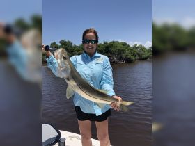 A proud angler holds up a freshly caught snook while enjoying a day of fishing on the water — a perfect moment for fishing enthusiasts.