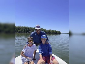A joyful moment captured with two kids and an adult on a boat, enjoying a sunny day on the water — perfect for family outings and adventures.