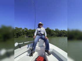 A man enjoys a day of fishing on a boat, showcasing the thrill of outdoor adventures on the water.