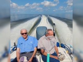 Two friends enjoy a day of fishing on a boat, capturing the essence of camaraderie and adventure on the water.