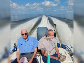 Two friends enjoy a day of fishing on a boat, capturing the essence of camaraderie and adventure on the water.