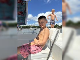 Two boys enjoy a sunny day on a boat, showcasing the fun and excitement of summer adventures on the water.