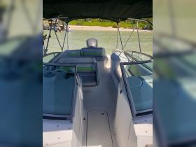 Interior view of a spacious boat cabin featuring comfortable seating and a helm, perfect for relaxing on the water.