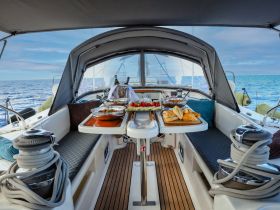 A beautifully arranged dining area inside a yacht, featuring a selection of gourmet dishes and a cozy seating space, perfect for enjoying meals while cruising on the open water.
