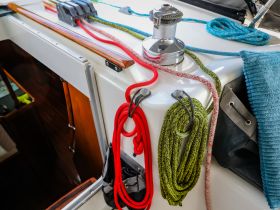 A close-up view of various ropes and equipment neatly arranged on the deck of a boat, showcasing essential amenities for sailing and boating activities.