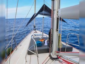 A beautifully arranged lounge area on a sailboat, featuring a selection of fresh fruits and towels, perfect for relaxing on the open water.