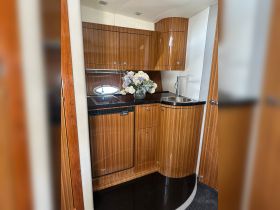 A beautifully designed boat interior featuring a modern kitchen area with elegant cabinetry and floral decor, perfect for onboard dining and relaxation.