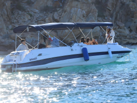 A lively group enjoys a day on the water in Cabo San Lucas, capturing memories aboard their boat — perfect for celebrations and fun outings.