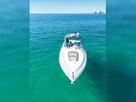 A stunning aerial view of a sleek boat cruising through crystal-clear turquoise waters, showcasing the perfect setting for a day on the water.